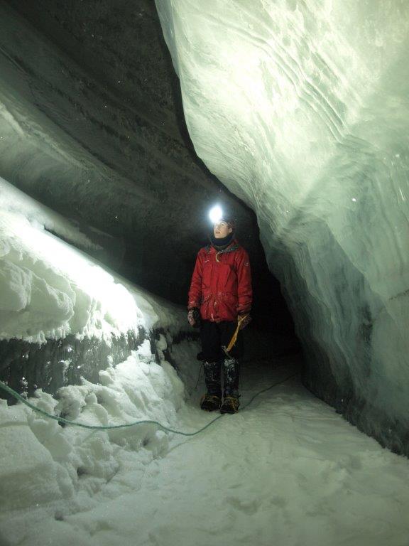 A student of the University Center on Svalbard peers at pretty crystal formations in Scott Turnerbreen glacier’s drainage system. Credit: Kiya Riverman.