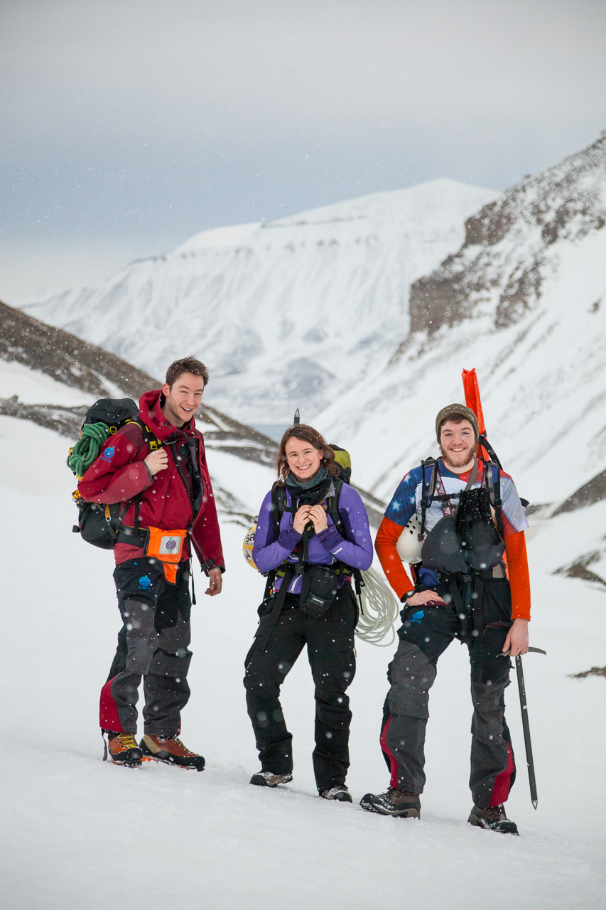 Glaciologists Stephen Jennings, Kiya Riverman and Nate Stevens (left to right) pause to catch their breath on their way up to the research site on Larsbreen Glacier. Credit: Ethan Welty.