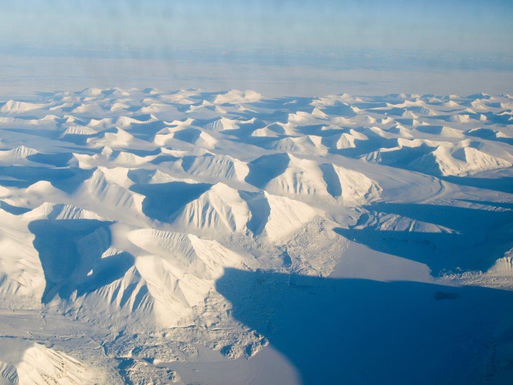 A sunny flight to the team’s field site in Svalbard shows a vast glaciated landscape. Credit: Kiya Riverman.